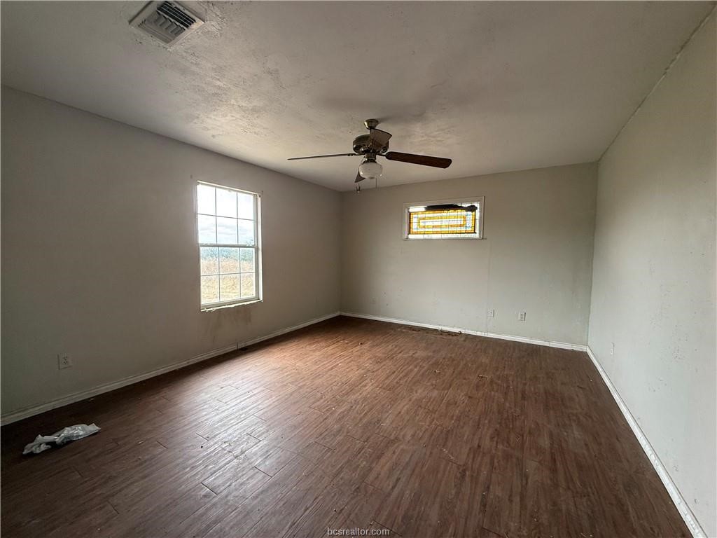 9776 Calhoun Road Bryan, TX 77808 - Photo 12 of 50 an empty room with windows and ceiling fan