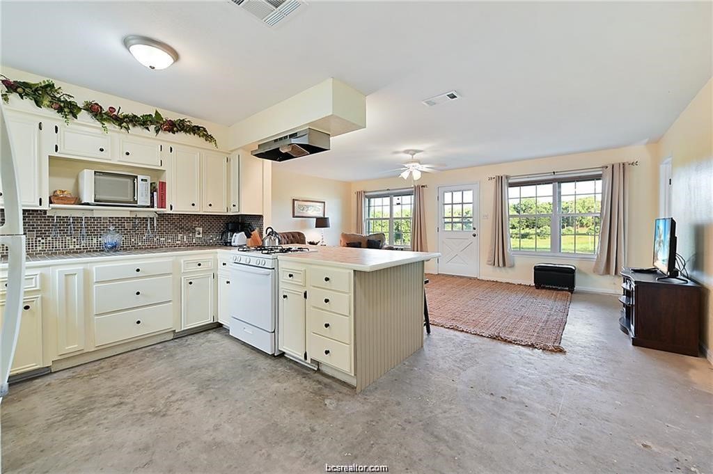 9776 Calhoun Road Bryan, TX 77808 - Photo 24 of 50 a large white kitchen with granite countertop a window