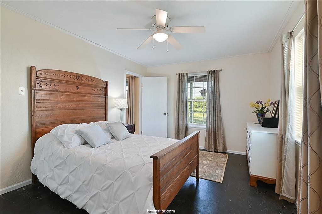 9776 Calhoun Road Bryan, TX 77808 - Photo 27 of 50 a bedroom with a bed and a chandelier