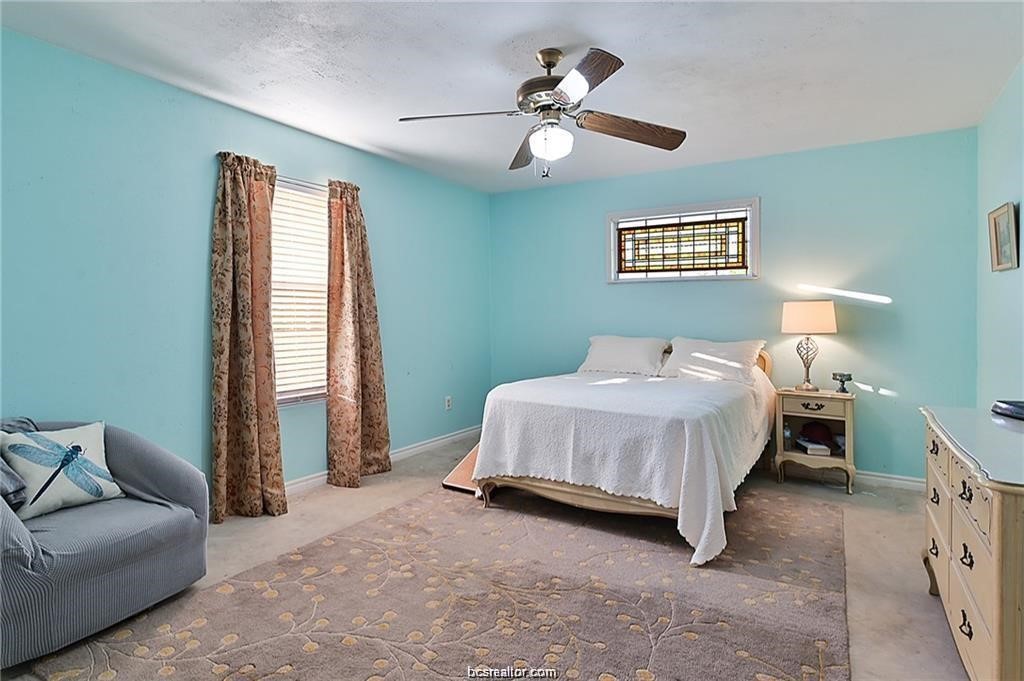9776 Calhoun Road Bryan, TX 77808 - Photo 30 of 50 a spacious bedroom with a bed and a couch