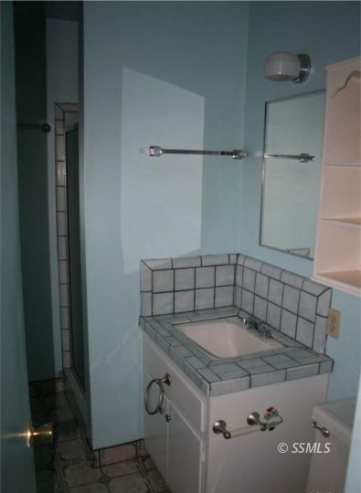 404 Karin Street Ridgecrest, CA 93555 - Photo 6 of 10 a bathroom with a granite countertop sink a toilet and shower