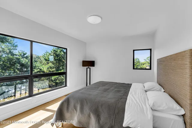 a bedroom with a bed and a large window