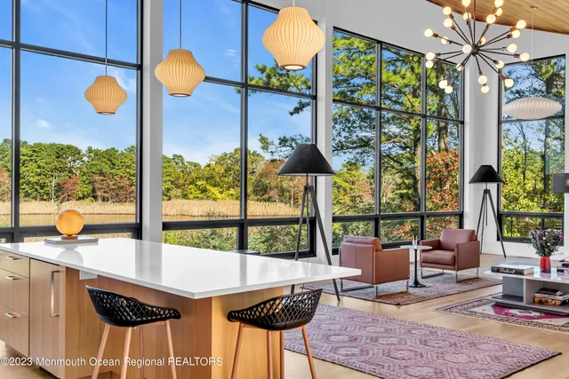 a very nice looking living room with a large window with kitchen view