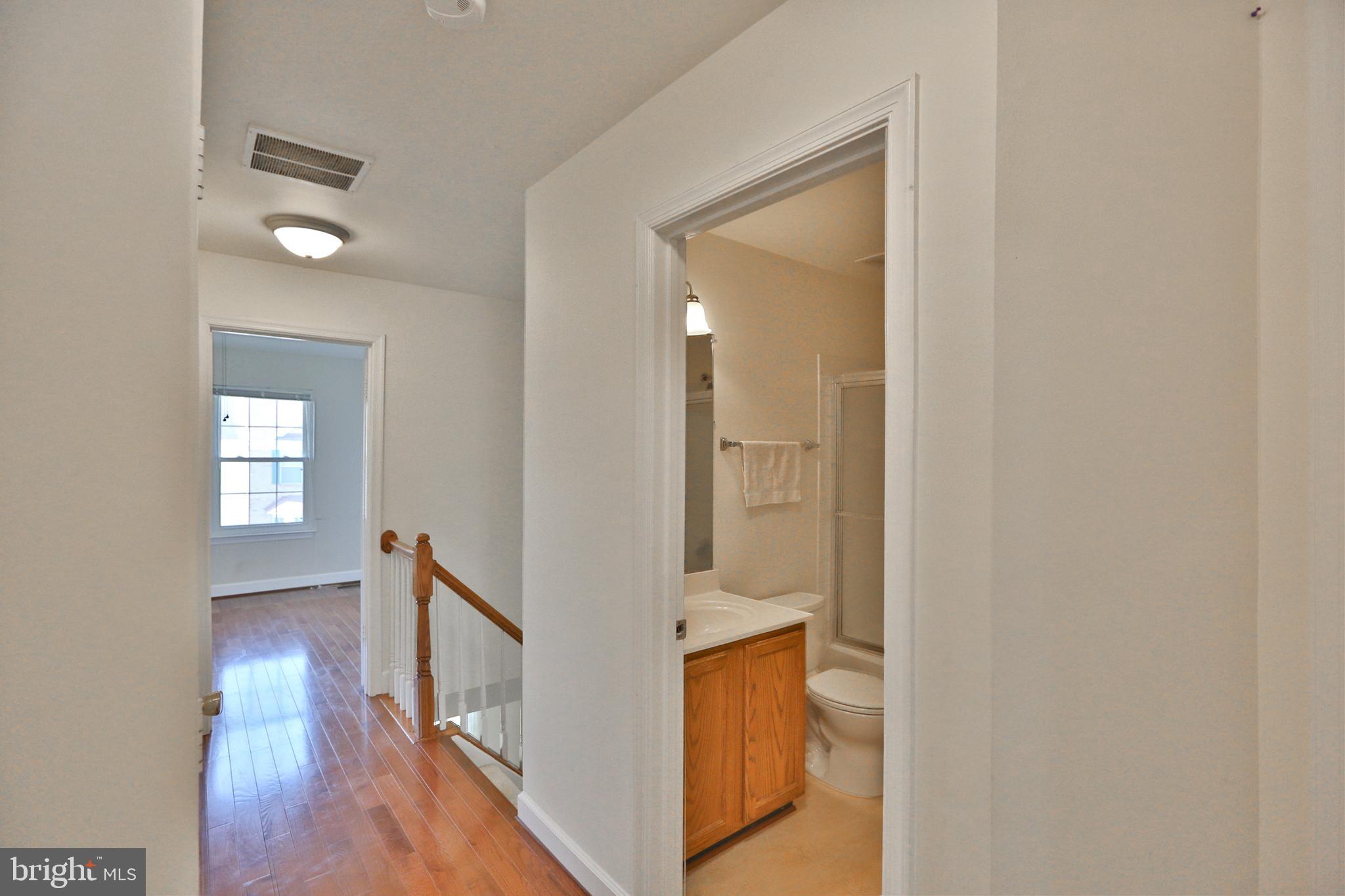 14214 Beddingfield Way Centreville, VA 20121 - Photo 12 of 19 a view of a hallway with wooden floor and staircase