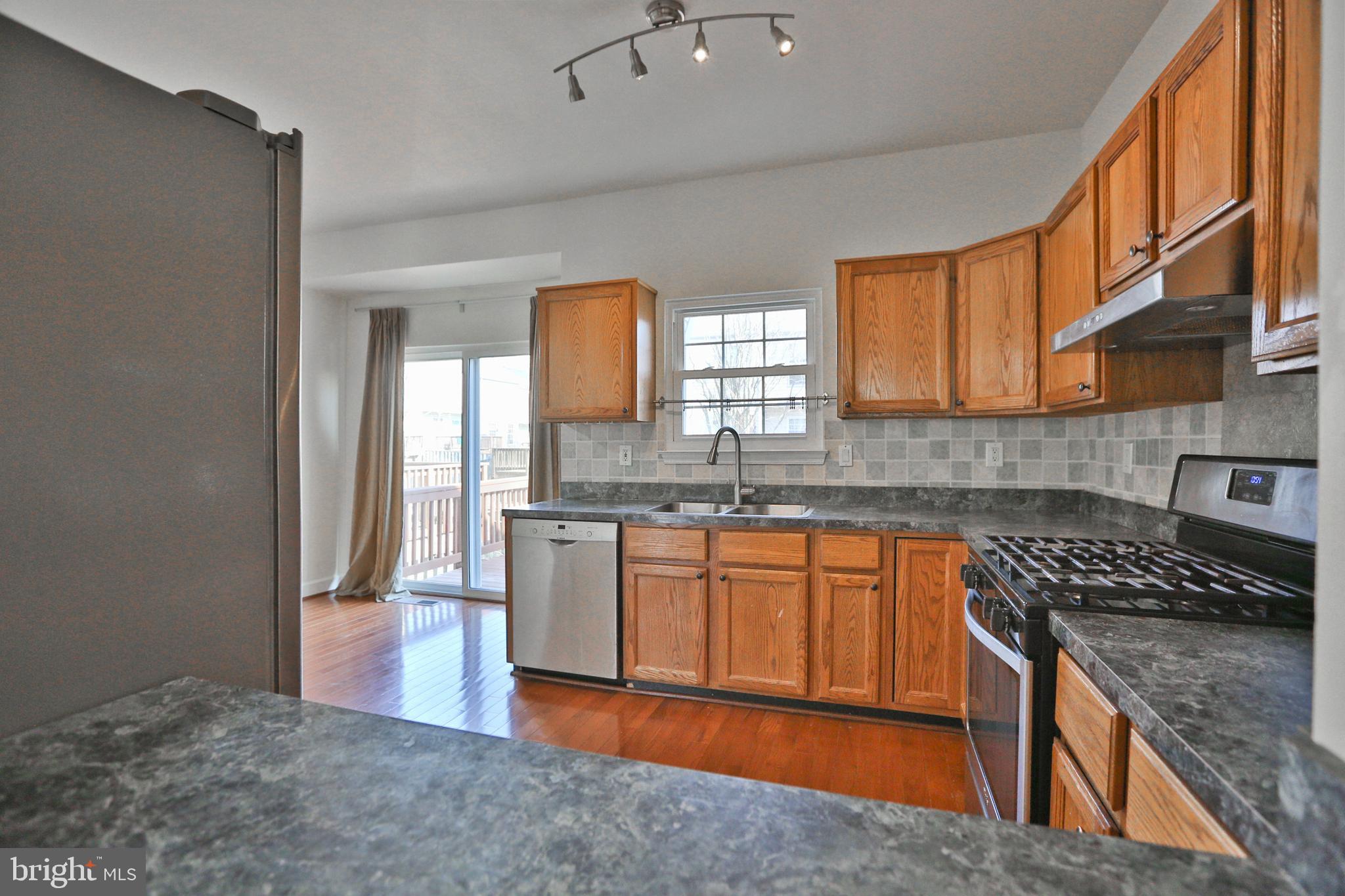 14214 Beddingfield Way Centreville, VA 20121 - Photo 15 of 19 a kitchen with stainless steel appliances granite countertop a stove a sink and a refrigerator