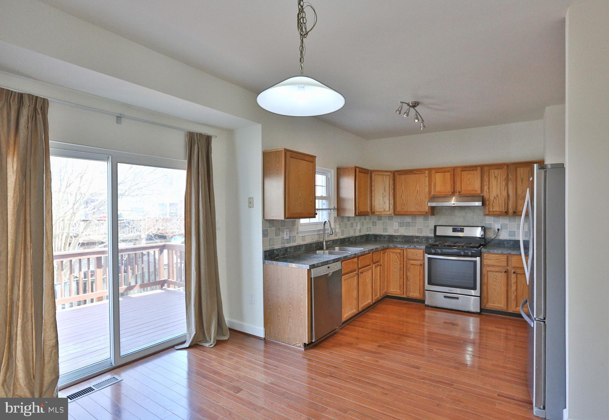14214 Beddingfield Way Centreville, VA 20121 - Photo 16 of 19 a kitchen with stainless steel appliances granite countertop wooden floors and white cabinets