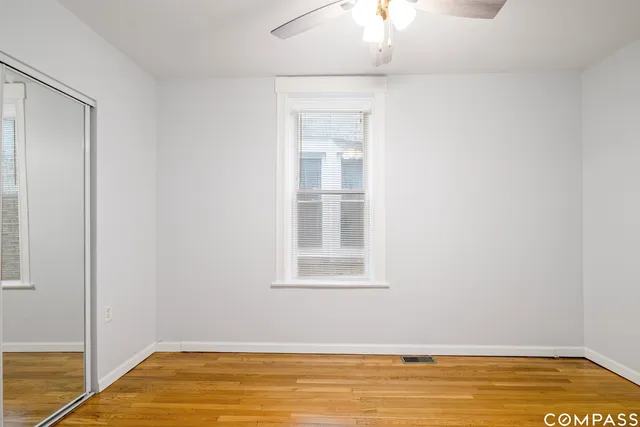 a view of a room with wooden floor and a window