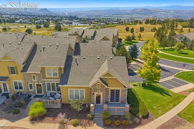 an aerial view of residential houses with outdoor space and ocean view