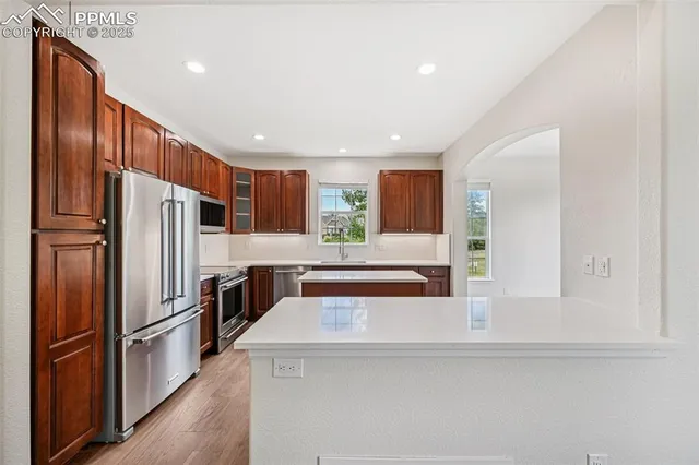a kitchen with stainless steel appliances a refrigerator and a stove top oven