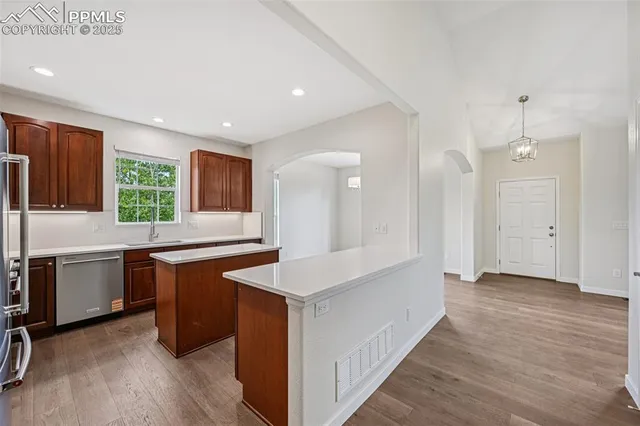 a large kitchen with granite countertop a large counter top space a sink stainless steel appliances and cabinets