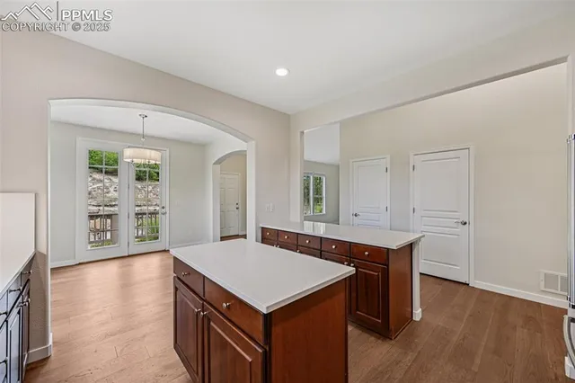 a kitchen with a stove a sink a refrigerator and wooden floor