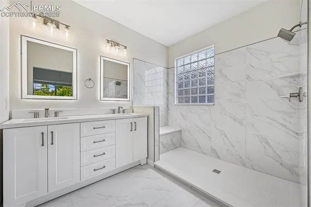a bathroom with a double vanity sink mirror and bathtub