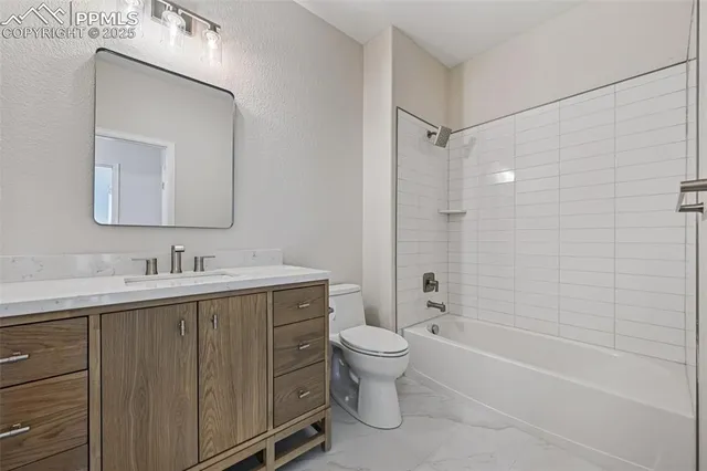 a bathroom with a bathtub shower sink mirror vanity and a toilet