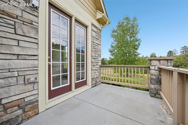 a view of a porch with a floor to ceiling window and wooden fence