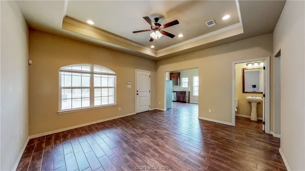 a view of an empty room and window and wooden floor