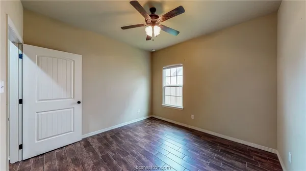 a view of a livingroom with a window and wooden floor