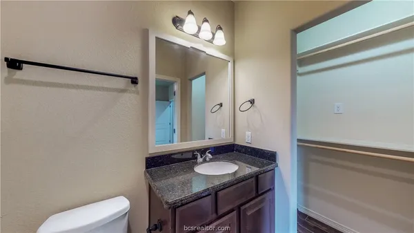 a bathroom with a granite countertop sink and a mirror