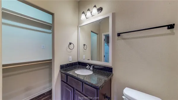 a bathroom with a granite countertop sink and a mirror
