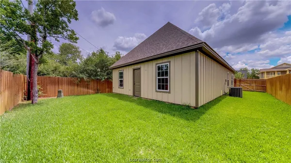 a front view of house with yard and trees in the background