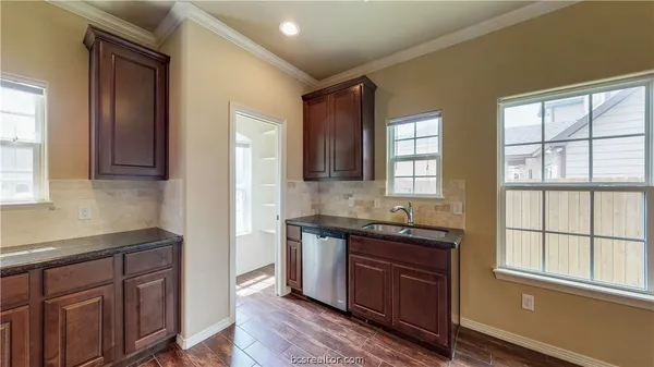 a kitchen with granite countertop wooden cabinets a sink and a window