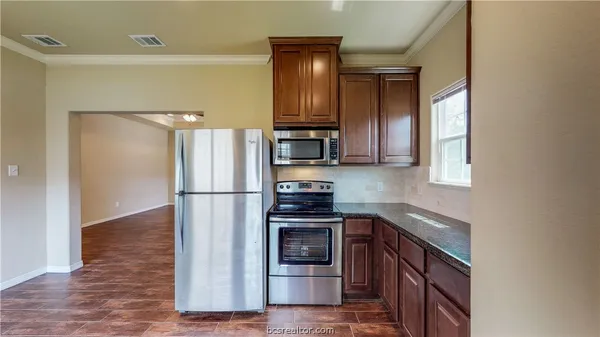 a kitchen with a refrigerator and a stove