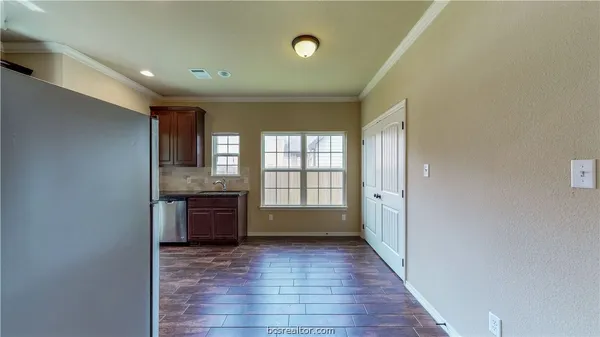 a view of an empty room with window and wooden floor