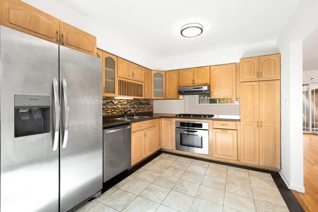 a kitchen with stainless steel appliances granite countertop a refrigerator and a stove