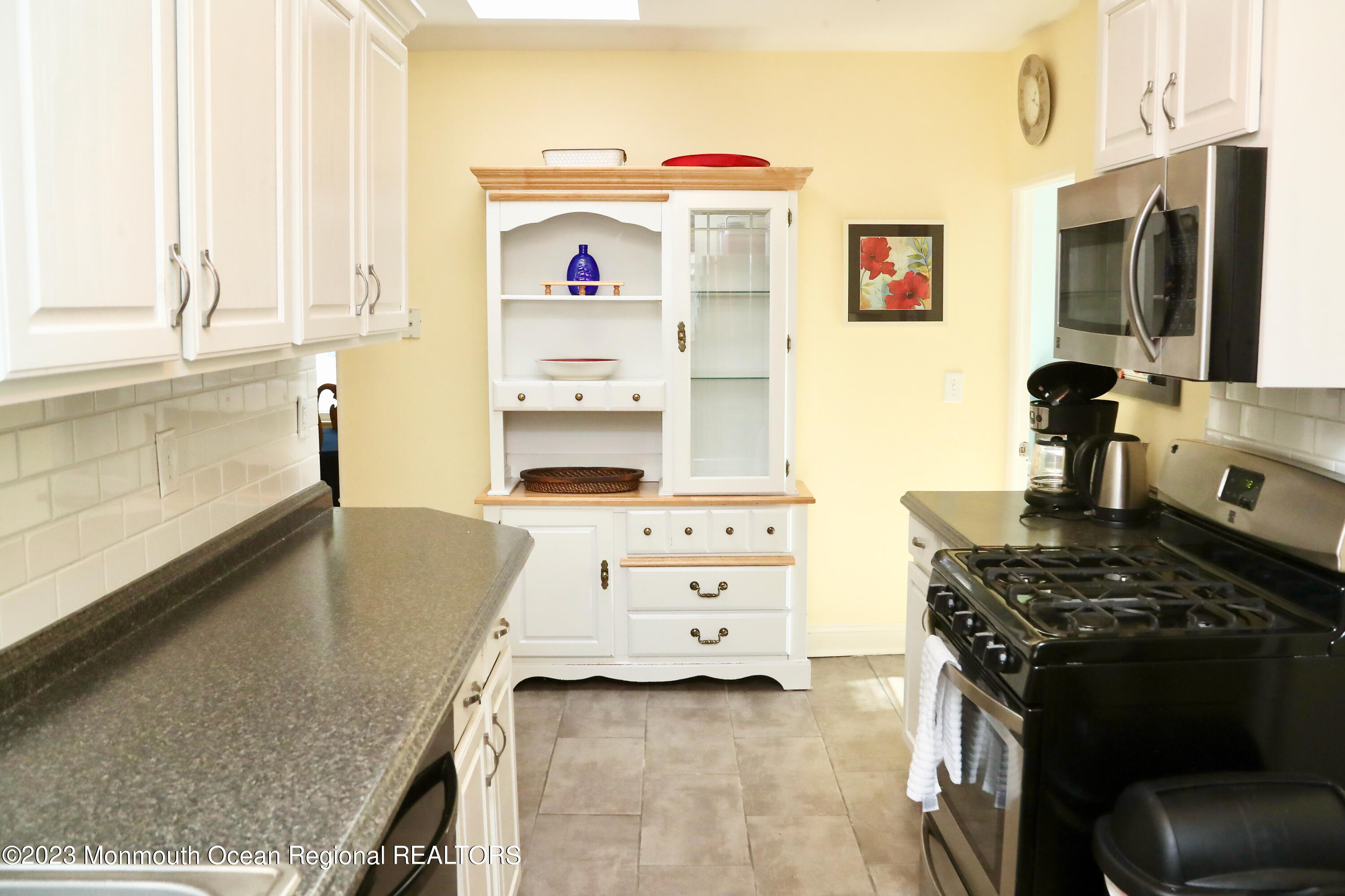 38 Ocean Pathway Ocean Grove, NJ 07756 - Photo 17 of 32 a kitchen with kitchen island a stove a sink and a refrigerator with wooden floor