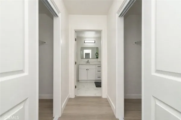 a view of a hallway with a white cabinet and a mirror