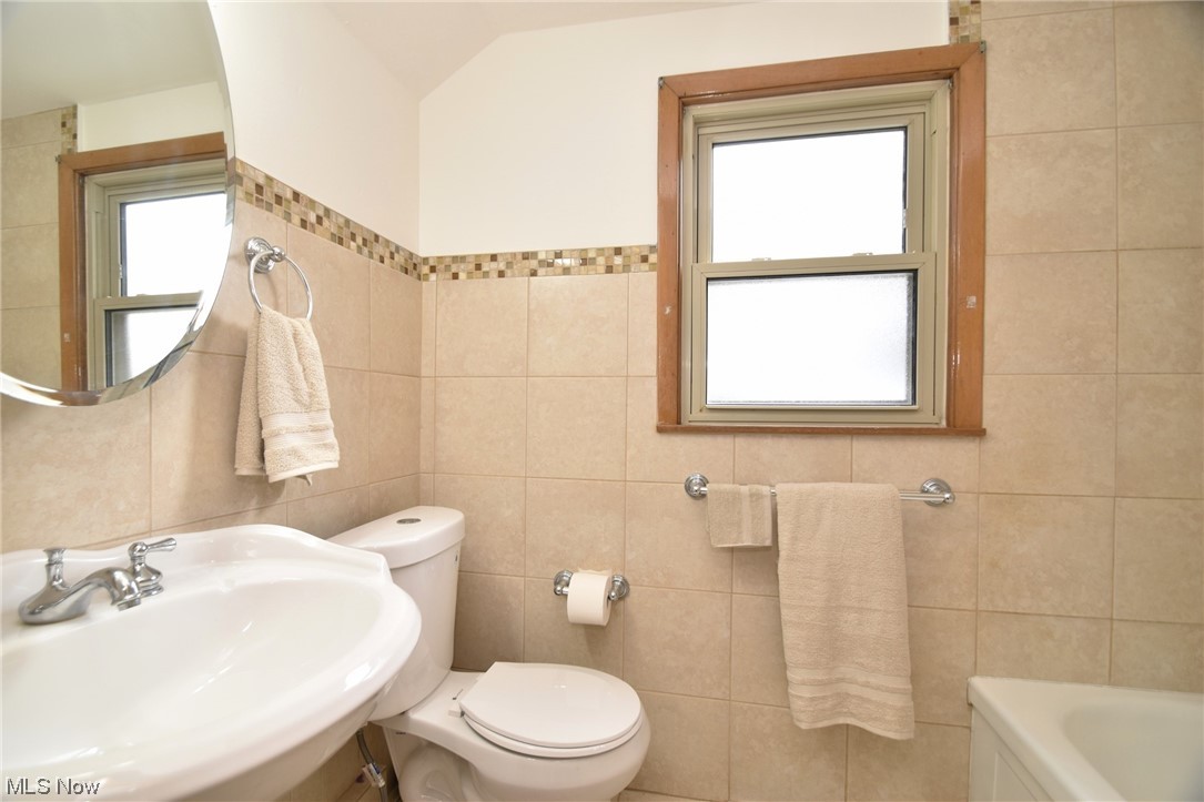 3681 Brinkmore Road Cleveland Heights, OH 44121 - Photo 21 of 27 Bathroom with a bath to relax in, toilet, tile walls, and sink