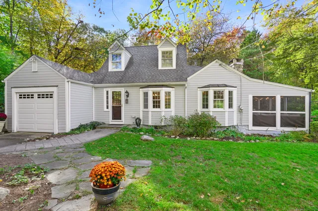 a front view of a house with a garden and yard