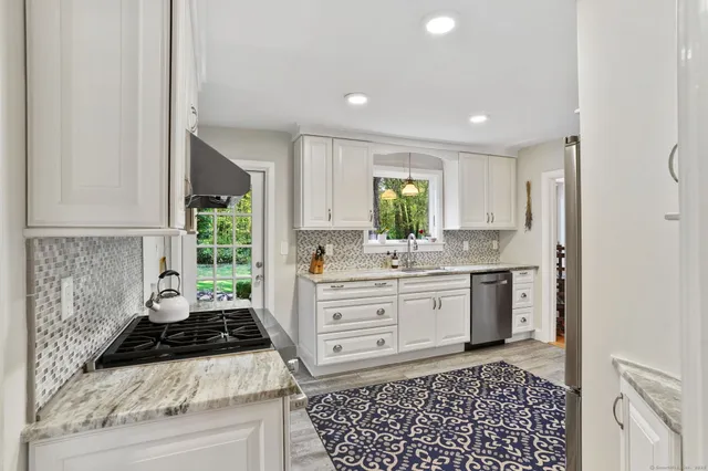 a kitchen with a stove a sink a refrigerator and window