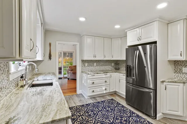 a kitchen with a refrigerator stove and white cabinets