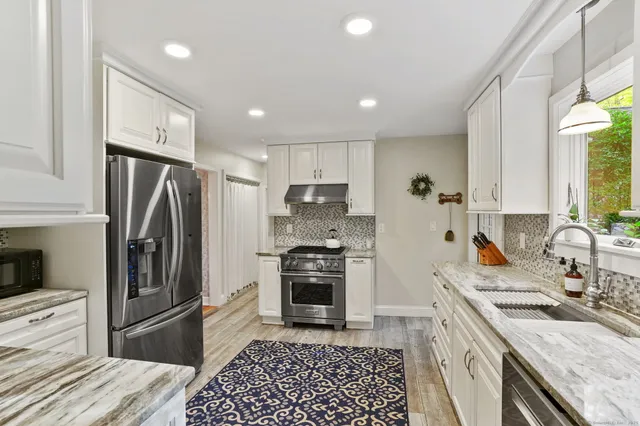 a kitchen with a refrigerator sink and wooden floor