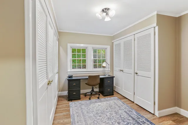 a view of a workspace with furniture and a window