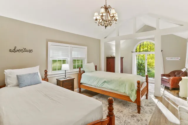 a bedroom with two beds and a chandelier