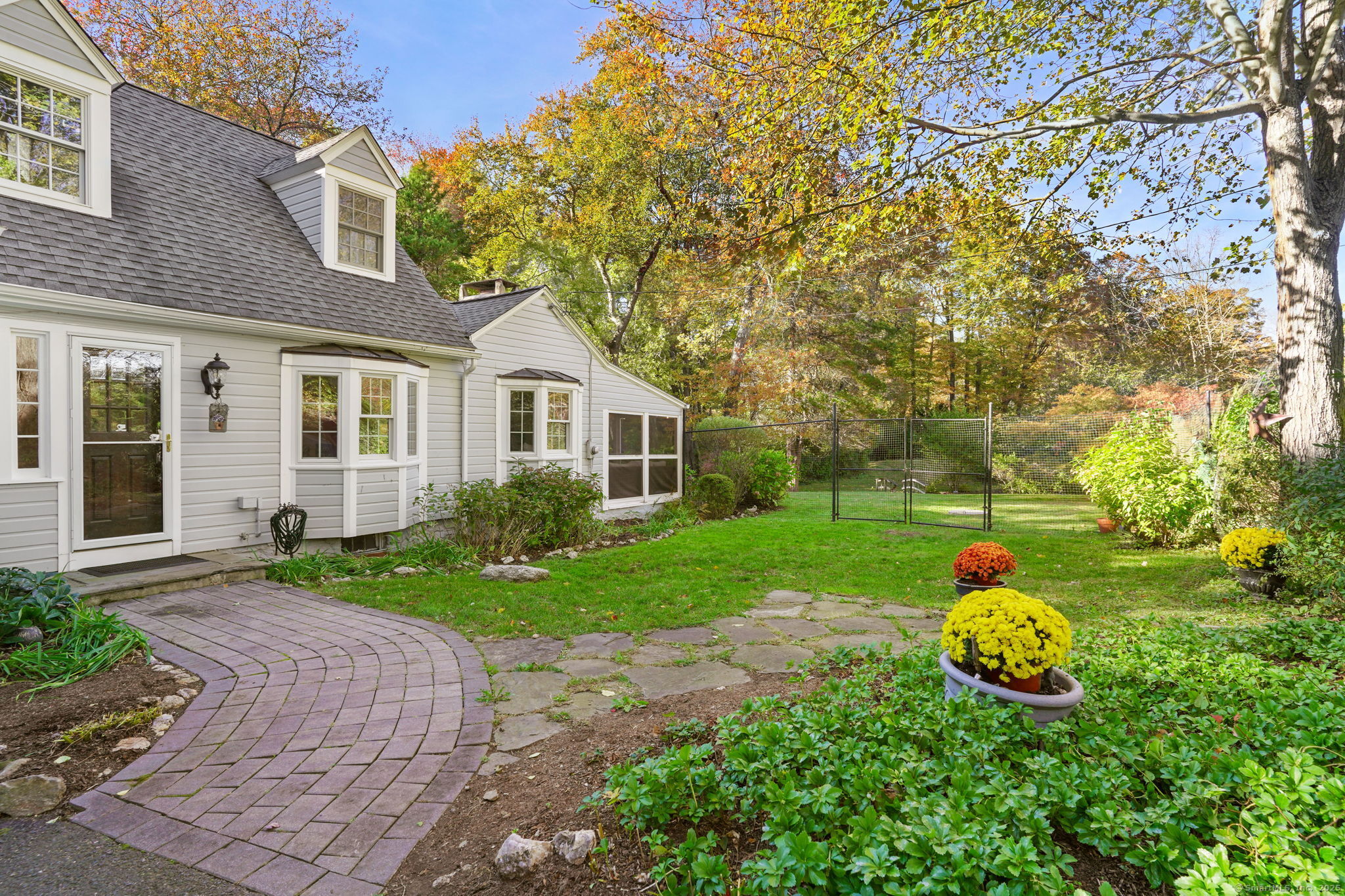 477 Newtown Turnpike Redding, CT 06896 - Photo 36 of 38 a backyard of a house with table and chairs plants and large tree