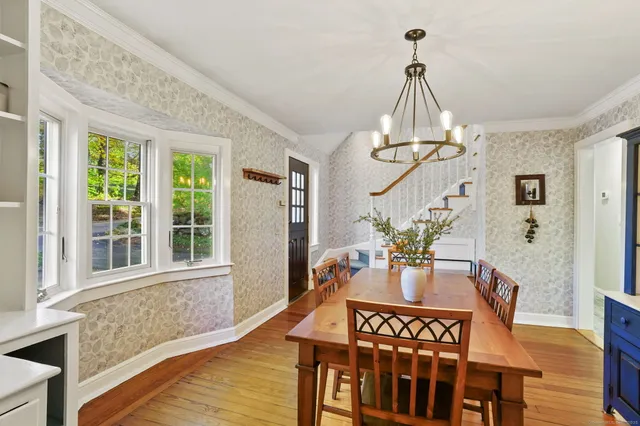 a view of a dining room with furniture a chandelier and wooden floor