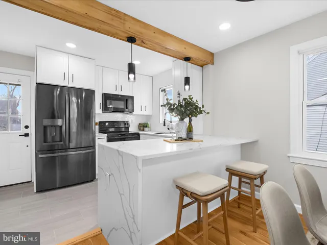 a kitchen with kitchen island a refrigerator and a stove