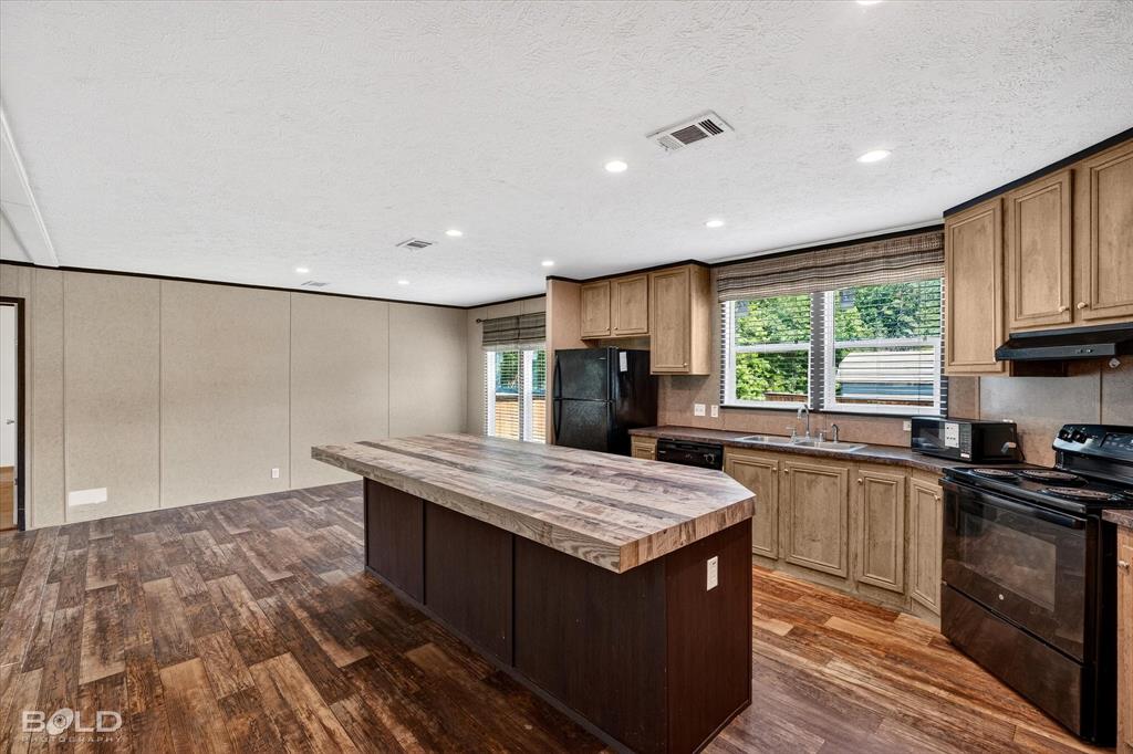 2153 Highway 2 Plain Dealing, LA 71064 - Photo 25 of 39 a kitchen with stainless steel appliances granite countertop a stove a sink dishwasher and a refrigerator with wooden floor