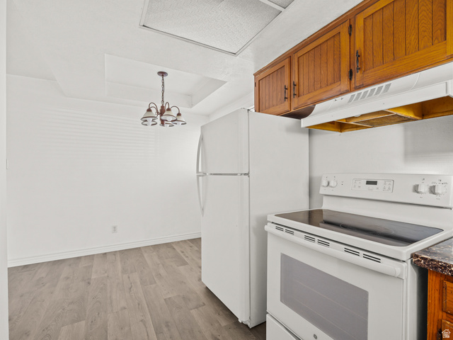 460 200 South Provo, UT 84606 - Photo 21 of 66 Kitchen with white appliances, light wood-style floors, a chandelier, wood finish cabinetry, and a raised ceiling