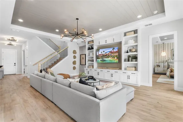 a kitchen with stainless steel appliances kitchen island granite countertop a dining table chairs and white cabinets