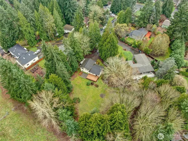 an aerial view of residential house with outdoor space and trees all around