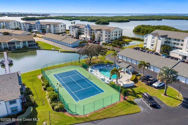 an aerial view of a pool with lawn chairs