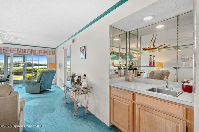 a kitchen with a sink and living room