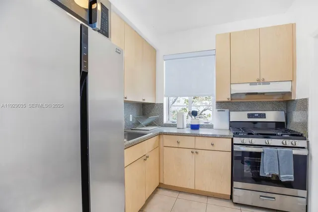 a kitchen with appliances a sink and cabinets