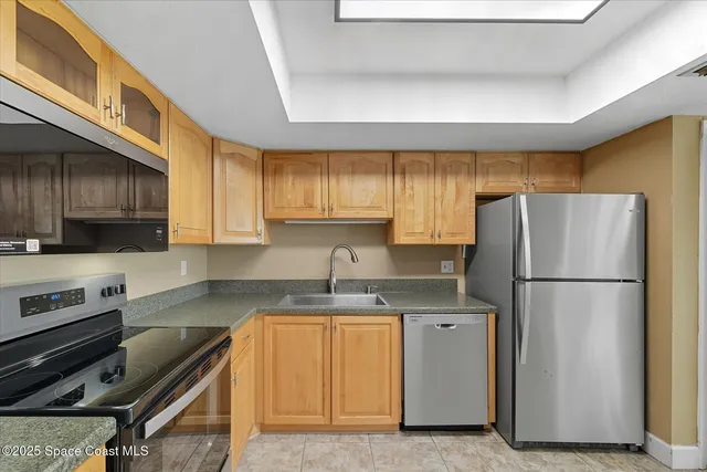 a kitchen with a refrigerator a stove a sink a microwave and cabinets