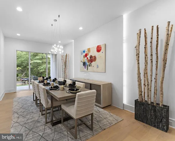 a dining room with furniture and a large window