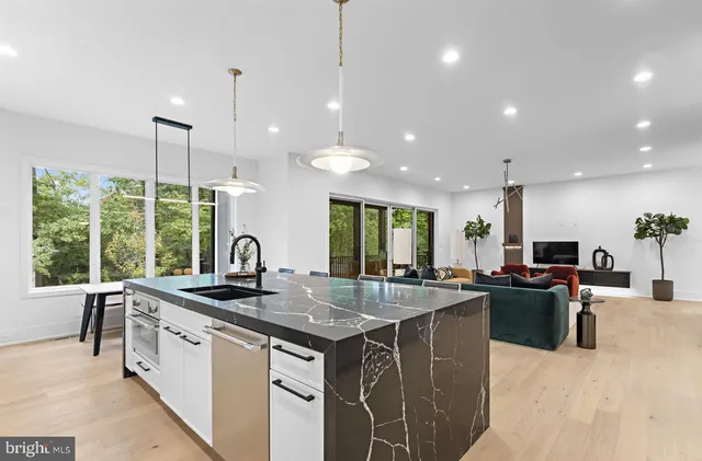a kitchen with stainless steel appliances granite countertop a sink a stove and a wooden floors