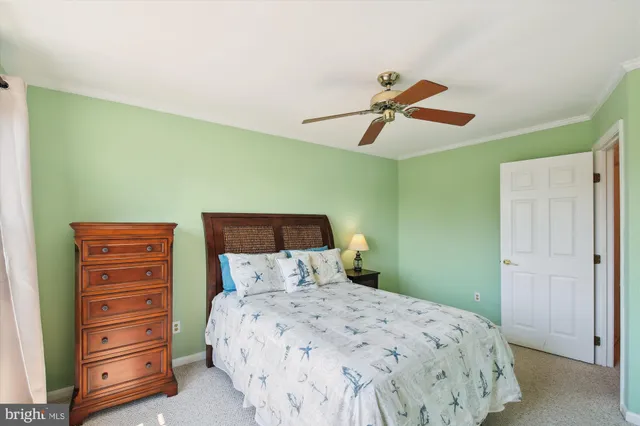 a bedroom with a bed a chandelier and a dresser